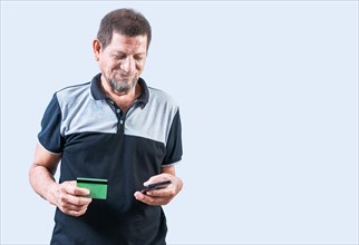 Smiling senior man holding credit card and smartphone isolated. isolated. Cheerful senior man