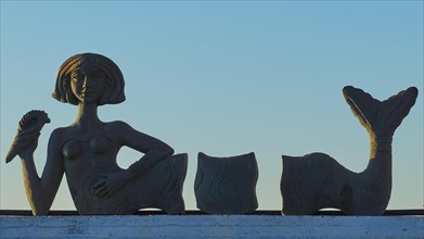 Sculpture of a reclining woman against the blue morning sky, mermaid, Gythio, Mani, Peloponnese,