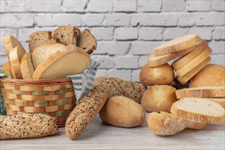 An assortment of bread and pastries in a beautiful basket on a wooden counter