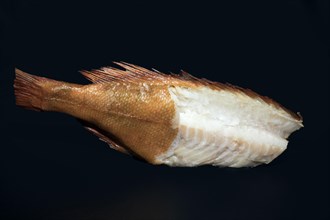 Smoked redfish without head, with half of the skin removed and part of the back fillet cut out,