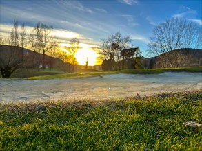 Golf Ball in a Sand Trap on Golf Course in Sunset in a Sunny Day in Switzerland