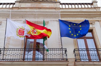 Spanish, european and ronda flags waving in the wind in a public building