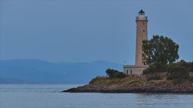 Lighthouse on the coast with trees at dusk, Gythio, Mani, Peloponnese, Greece, Europe