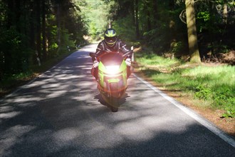 Sporty motorcyclist on a trip into the countryside (Edenkoben Valley, Palatinate Forest)