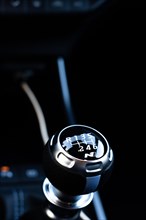 Vertical photography of the manual gearshift lever of a luxury car with dark interior