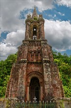Close-up of an old Gothic church tower of Capela de Nossa Senhora das Vitorias with a cross against