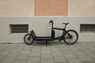 Cargo bike in front of a house wall