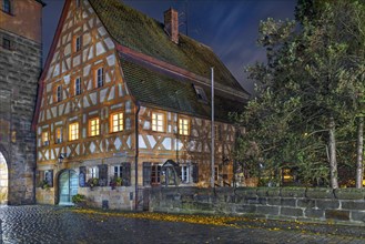 Historic half-timbered house from 1799, in the old town at night in autumn rain, Lauf an der
