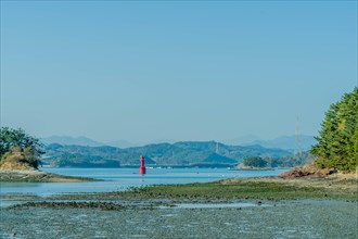 Red channel marker beacon between two islets at low tide in South Korea