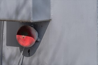 Red alarm bell on rear of military gun firing control system on display in public park