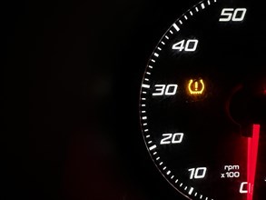 Car dashboard panel icon on a black background. Tire pressure monitoring
