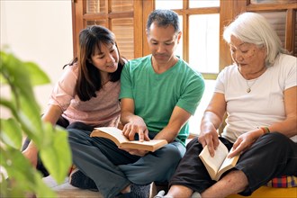 Japanese family reading books. Mother and adult children sharing a moment of reading