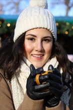 Symbolic image: Cheerful young woman at a Christmas market