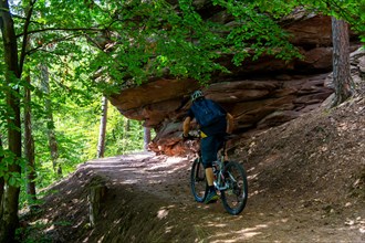 Mountain bikers on tour in the Dahner Felsenland . The many red sandstone rock formations