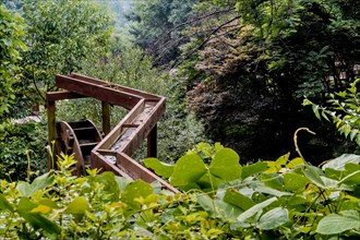 Wooden water trough and waterwheel in lush mountain recreational park in South Korea