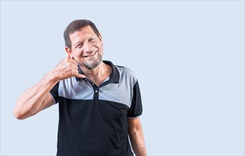 Cheerful senior man making call gesture with hand. Smiling mature man making telephone gesture with