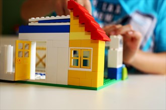 Boy builds a house with building blocks
