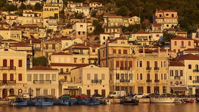 The warm colours of the evening sun shine on the traditional buildings and boats on the coast,