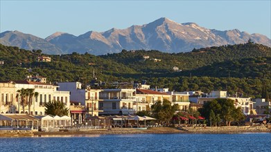 Coastal town at sunrise with a view of the sea and mountains in the background, Taygetos Mountains,