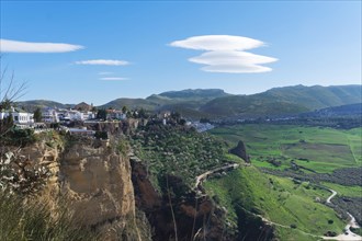 Green landscape of a village on a cliff with blue sky with cotton clouds