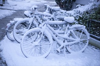 Snow-covered bicycles at a bicycle stand in winter, Bremen, Germany, Europe
