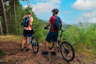 A mountain biking couple taking a break at a beautiful viewpoint in the Palatinate Forest