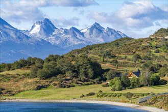 House on the coast of the Beagle Channel, behind the mountains of Hoste Island, Ushuaia, Tierra del