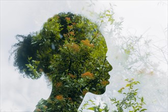 Aesthetic double exposure of a woman with dense green plant growth, symbolic image for