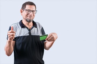 Senior man with credit card making money gesture with fingers, isolated. Senior people holding