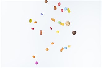 Colourful sweets fall against a white background