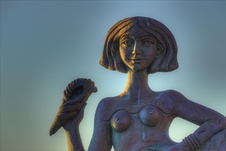Detailed sculpture of a woman in front of a sunrise sky, mermaid, Gythio, Mani, Peloponnese,