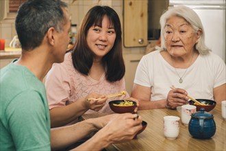 Elderly Japanese Mother with adult children having lunch at home. Concept of family, tradition and