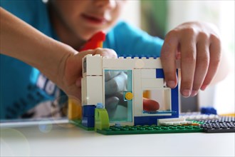 Boy builds a house with building blocks