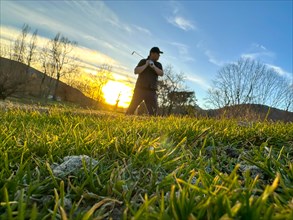 Golfer in a Sand Trap on Golf Course in Sunset in a Sunny Day in Switzerland