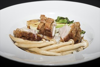 Crispy fried pork belly on Japanese udon noodles, with briefly braised pak choi and enoki