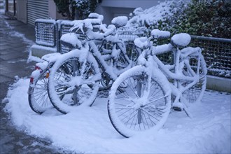 Snow-covered bicycles at a bicycle stand in winter, Bremen, Germany, Europe