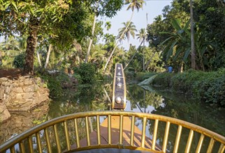 View from the bow of a cruise boat offers a perspective of a canal near Kumarakom, Kerala