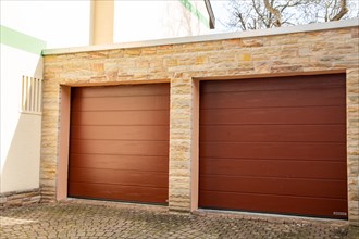 Two red sectional doors from the manufacturer Hoermann on the garage of a detached house