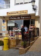 People entering the Oficina de Turismo tourist information shop and office, village of Nijar,