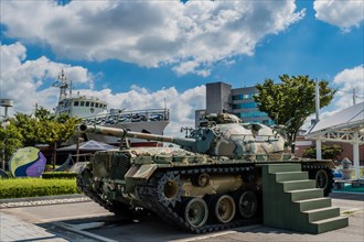 Side view of M48 tank on display at seaside park under blue cloudy sky in Seosan, South Korea, Asia