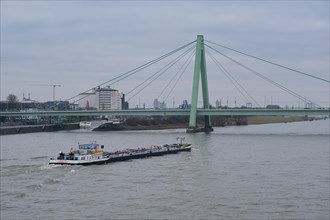 View over the Rhine with cargo ship and bridge, Cologne, Germany, Europe