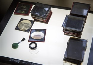 Magic lantern slides, brush, magnifying loop on Vis-Tra-Lite Lightbox, old photographs