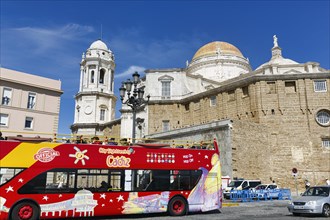 Red double-decker bus with tourists in front of the cathedral of Cadiz, Cathedral of the Holy Cross