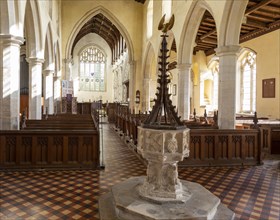 Interior historic village parish church, Wingfield, Suffolk, England, UK baptismal font and nave