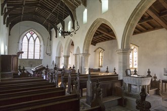 Interior of historic wooden pews, wooden roof beams, whitewashed walls and columns, All Saints