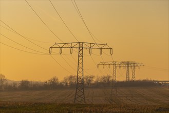 Evening light over fields near Krebs in the Osterzgebirge, electricity pylons can be seen