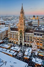 Snow-covered Marienplatz with Christmas market, Christmas market and town hall in the evening sun,