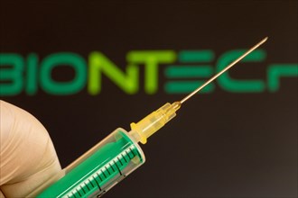 Corona vaccination/Biontech symbol: close-up of an injection needle, with the Biontech logo in the