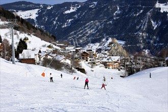 Ladis in winter, the ski piste in the foreground and the village with Laudegg Castle in the