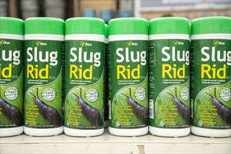 Plastic containers of organic Vitax Slug Rid bait on shelf display in garden centre, UK